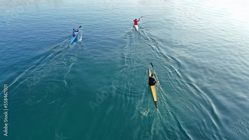 Aerial drone abstract slow shutter photo of athletes competing in sport canoe in tropical exotic lake with emerald waters
