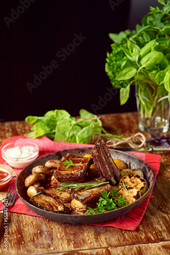 Roasted pork ribs with grilled vegetables in a pan. Meat grilled close up