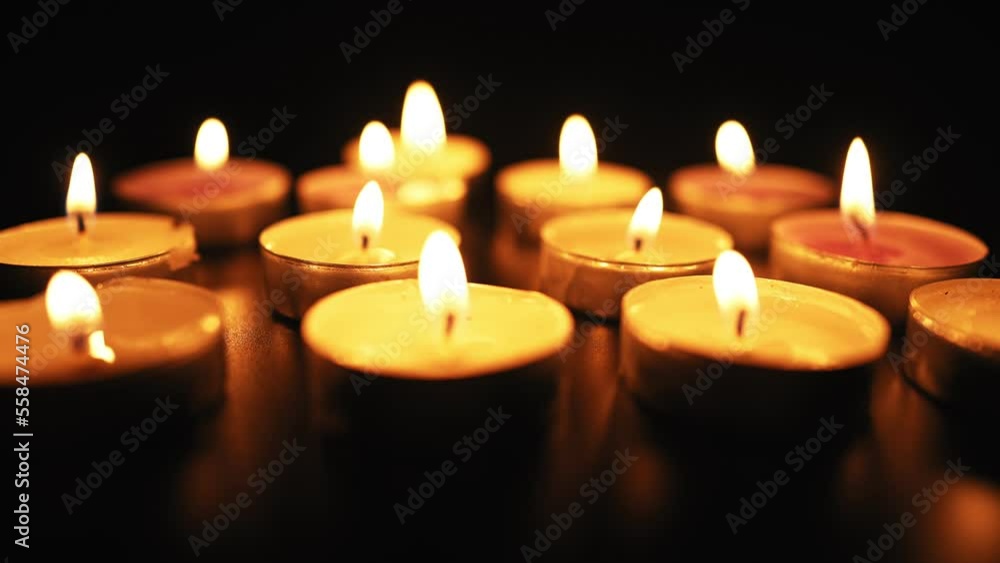 Candles Burn with a Soft Yellow Flame in the Dark. Religion and Funeral Concept. Sorrow for the Dead. Slow Motion. Candles Burn with a Soft Yellow Flame in the Dark. Religion and Funeral Concept. Sorrow for the Dead. Slow Motion.