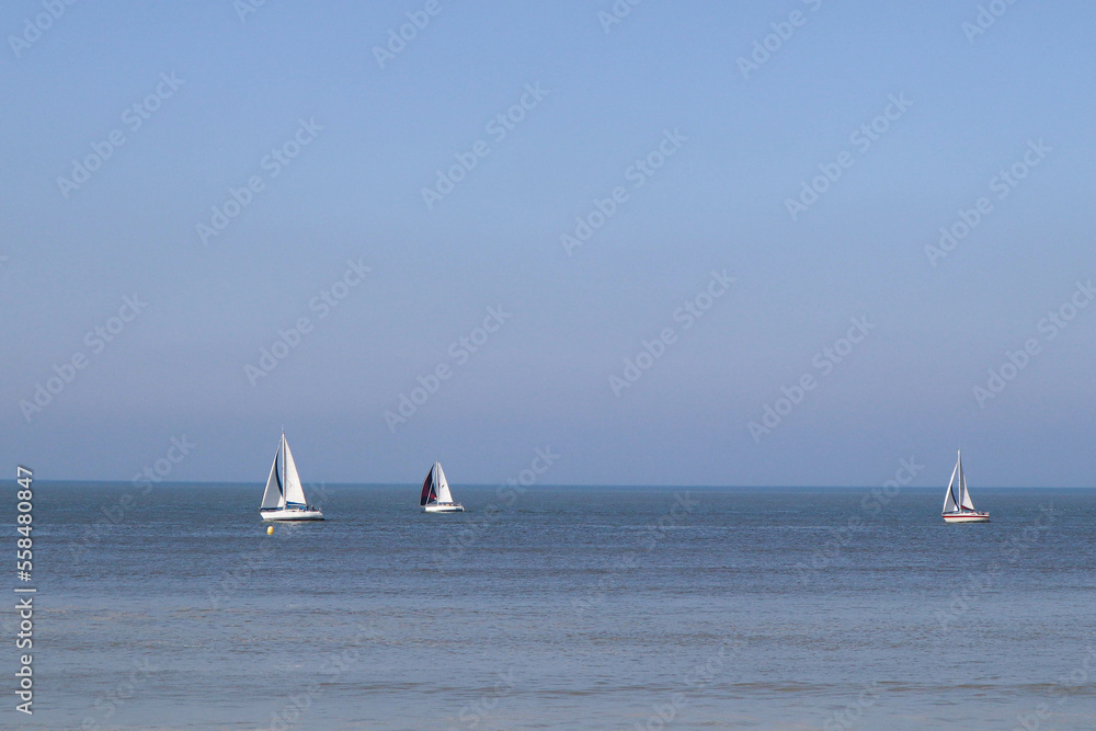 Trois bateaux à voile sur la mer bleue