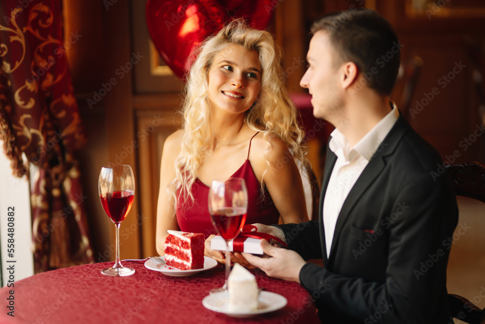 Man presenting gift to his girlfriend.Valentine's day celebration. Relationship and love concept. Man presenting gift to his girlfriend.Valentine's day celebration. Relationship and love concept.