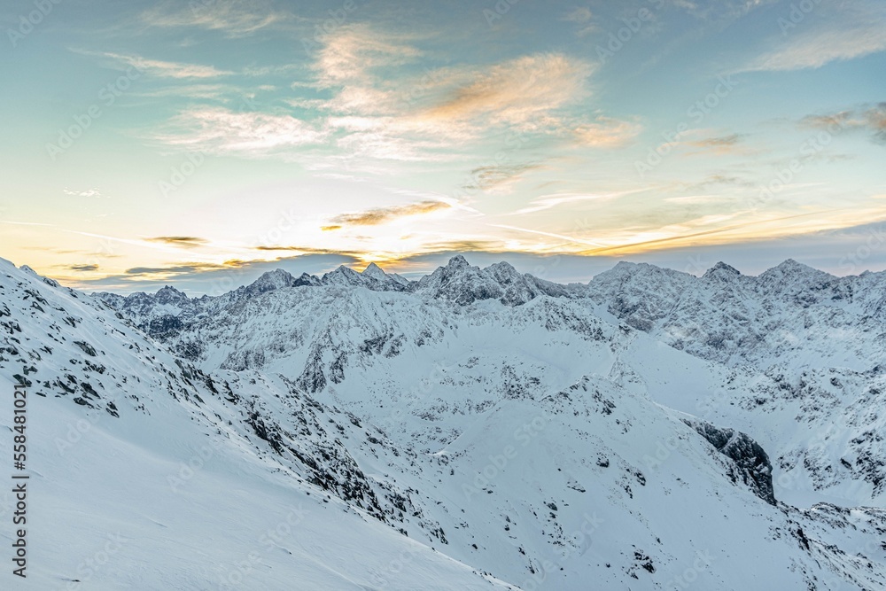 Sunrise over snowy hills on the Zawrat Pass in the winter Tatra Mountains. Winter and sunrise in Polish mountains