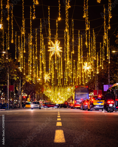 Yellow Christmas lights on over a boulevard at rush hour