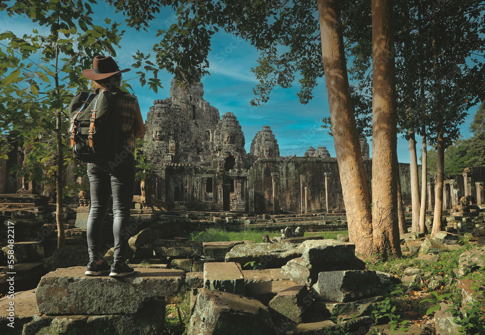 Obraz premium Soft focus on tourist standing in front of Angkor Wat temple in Siem Reap, Cambodia. Angkor Wat is the largest religious monument in the world.
