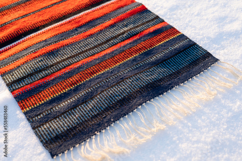Traditional handwoven Sami fabric, raanu, in the snow.
Finland