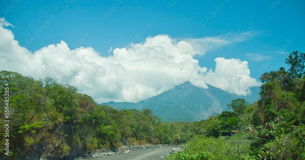 Inactive Volcano de Aqua with clouds among forest in Antigua, Guatemala