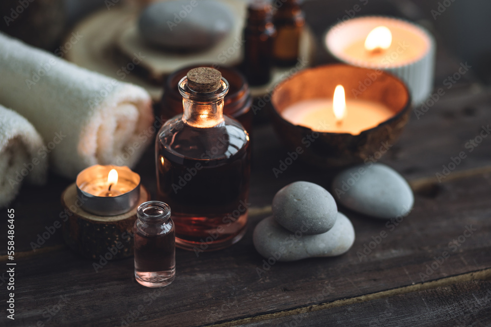 Concept of natural essential organic oils, Bali spa, beauty treatment, relax time. Atmosphere of relaxation, pleasure. Candles, towels, dark wooden background. Alternative oriental medicine Concept of natural essential organic oils, Bali spa, beauty treatment, relax time. Atmosphere of relaxation, pleasure. Candles, towels, dark wooden background. Alternative oriental medicine