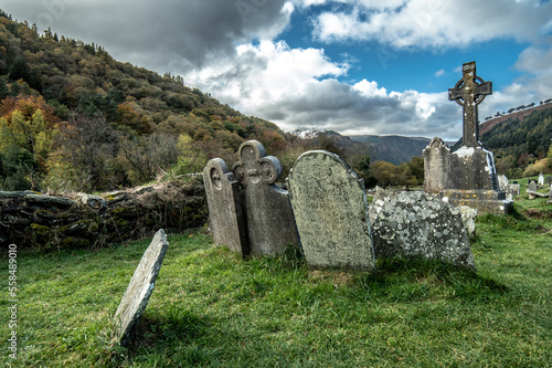 Irish stone cross and headstones in cemetery