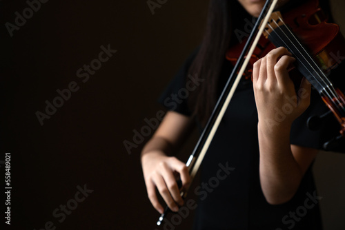 Teen playing violin in formal wear