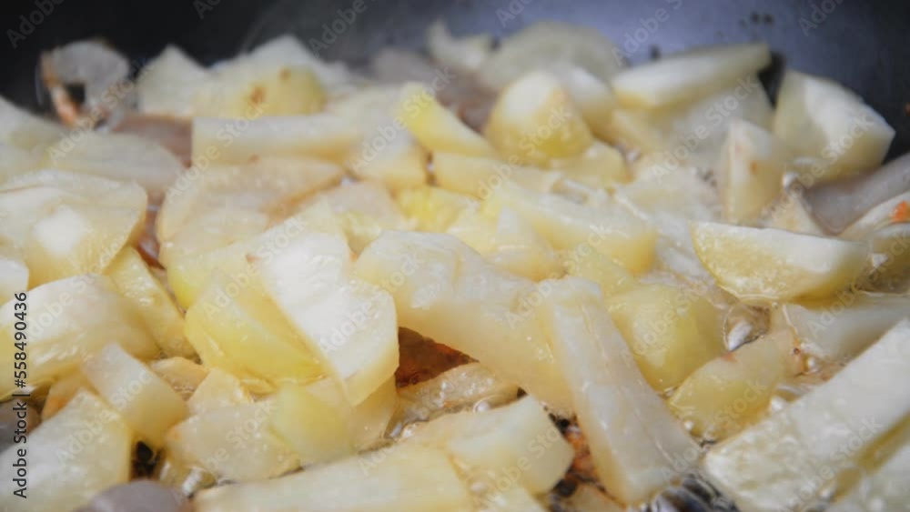 potatoes are fried in a frying pan in oil close up potatoes are fried in a frying pan in oil close up
