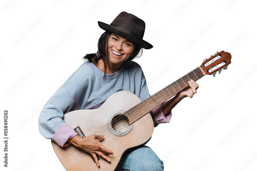 Young beautiful cheerful hispanic woman smiles widely and playing guitar, dressed in a light sweater and a brown hat with a brim on transparent background, saw something funny and laughed. Young beautiful cheerful hispanic woman smiles widely and playing guitar, dressed in a light sweater and a brown hat with a brim on transparent background, saw something funny and laughed.