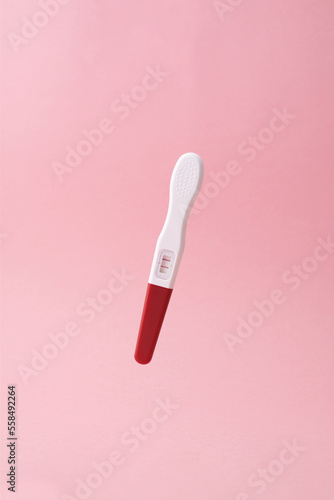 Positive pregnancy test on pink background