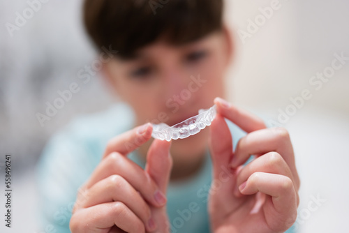 Teenager boy wear simulator orthodontic silicone invisible leveling braces for teeth. Dental concept, orthodontics.