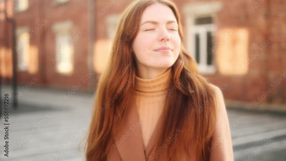 Dreamy soft portrait of charming young red haired ginger woman with freckles looking around on the street in the city centre alone Dreamy soft portrait of charming young red haired ginger woman with freckles looking around on the street in the city centre alone
