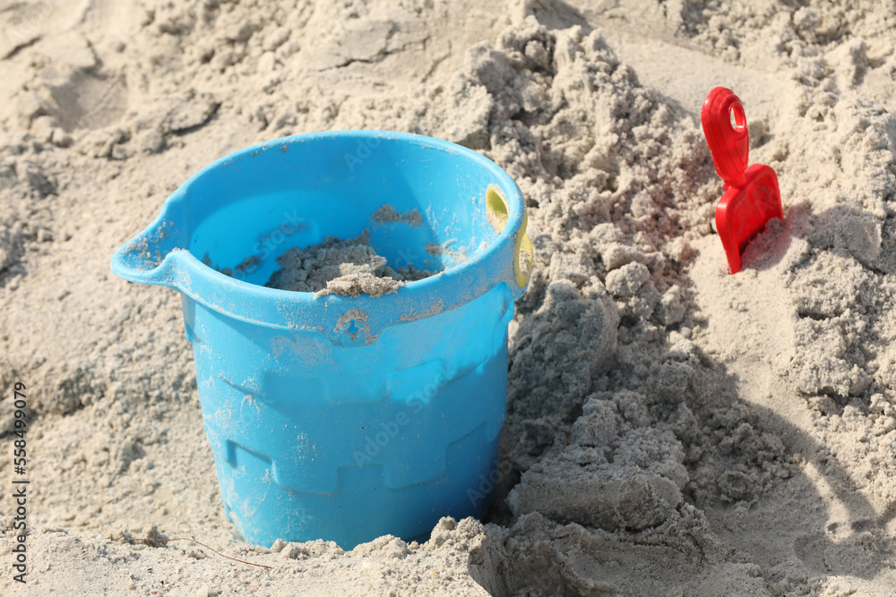 blue bucket and shovel in the sand at the beach blue bucket and shovel in the sand at the beach