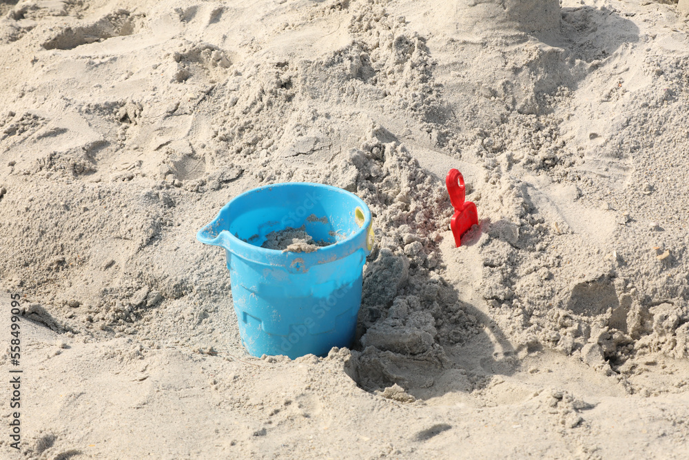 blue bucket and shovel in the sand at the beach blue bucket and shovel in the sand at the beach