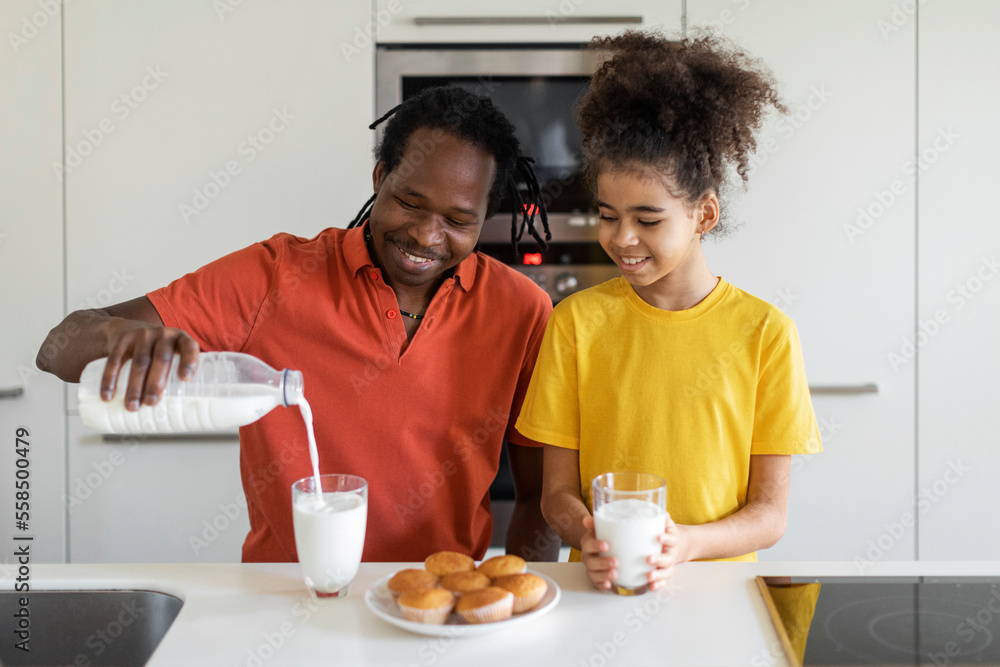 African American Father And His Preteen Daughter Having Snacks In Kitchen African American Father And His Preteen Daughter Having Snacks In Kitchen
