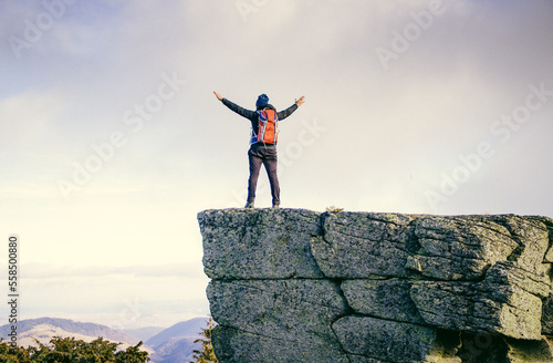 man standing on top of a rock in nature