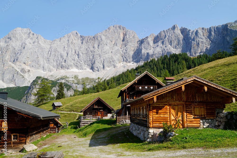 Obraz premium hiking trail leading through the scenic alpine village Neustatt Alm or Neustatt valley by the foot of Dachstein mountain in the Austrian Alps in Steiermark or Styria region (Austria)