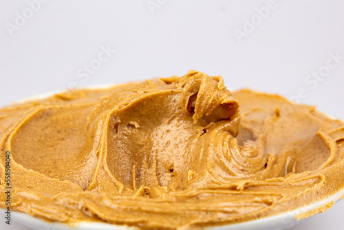 Peanut butter texture background. Creamy smooth brown walnut swirl close up. Delicious dark natural food pasta macro.