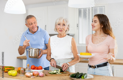 Happy family of three preparing lunch together in a modern kitchen