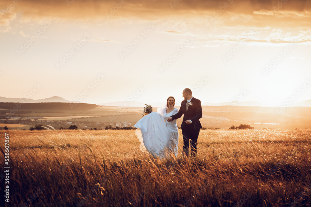 The bride and groom hold hands and look to the future in the middle of nature, the newlyweds walk together,wedding photography,until death do us part The bride and groom hold hands and look to the future in the middle of nature, the newlyweds walk together,wedding photography,until death do us part
