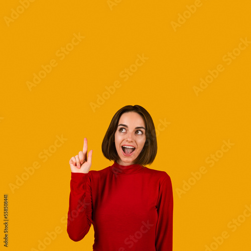 Happy millennial woman pointing upwards showing eureka gesture