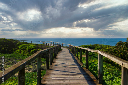 Wooden trail in the rocky cliffs over the ocean