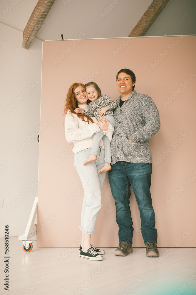 Family of 3 smiling together for a family portrait in a photo st Family of 3 smiling together for a family portrait in a photo st