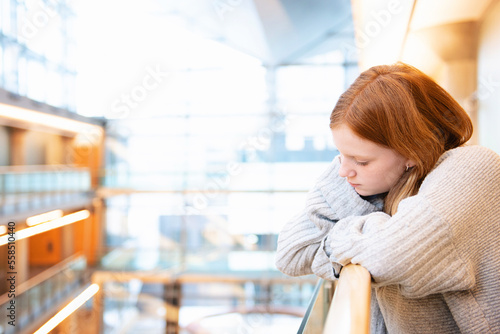 Teen girl with red hair in urban library. photo