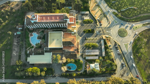 Vista aerea de un hotel con encanto y piscina en mitad de carretera y ciudad. DJI MAVIC 3 CLASSSICAerial view of a charming hotel and swimming pool in the middle of the road and the city. DJI MAVIC 3