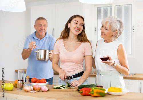 Happy family of three preparing lunch together in a modern kitchen