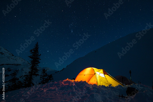 A headlamp is used to light up a tent below a starry night sky in British Columbia, Canada. photo