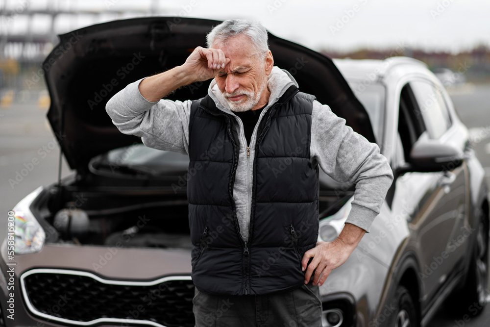 Sad senior man driver feeling emotional stress holding hand on head