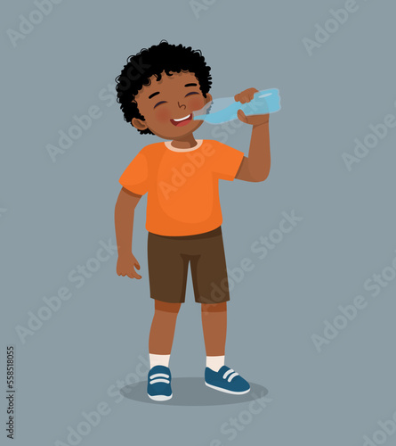 Cute little African boy feeling thirsty drinking fresh water from a bottle