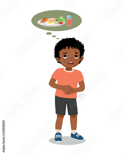 Cute little African boy feel hungry touching her stomach want to eat breakfast 