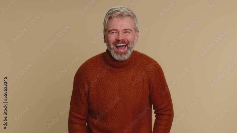Amused middle-aged man pointing finger to camera, laughing out loud, taunting making fun of ridiculous appearance, funny joke anecdote. Senior mature guy isolated alone on beige studio background Amused middle-aged man pointing finger to camera, laughing out loud, taunting making fun of ridiculous appearance, funny joke anecdote. Senior mature guy isolated alone on beige studio background