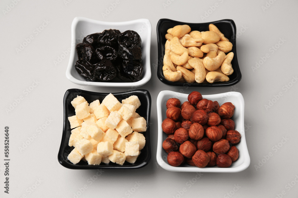 Bowls with dried fruits and nuts on beige background, above view Bowls with dried fruits and nuts on beige background, above view