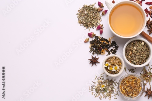 Composition with fresh brewed tea and dry leaves on white background, top view. Space for text