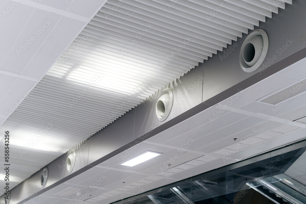 Obraz premium Ceiling mounted cassette type air conditioner and modern lamp light on white ceiling. duct air conditioner for home or office