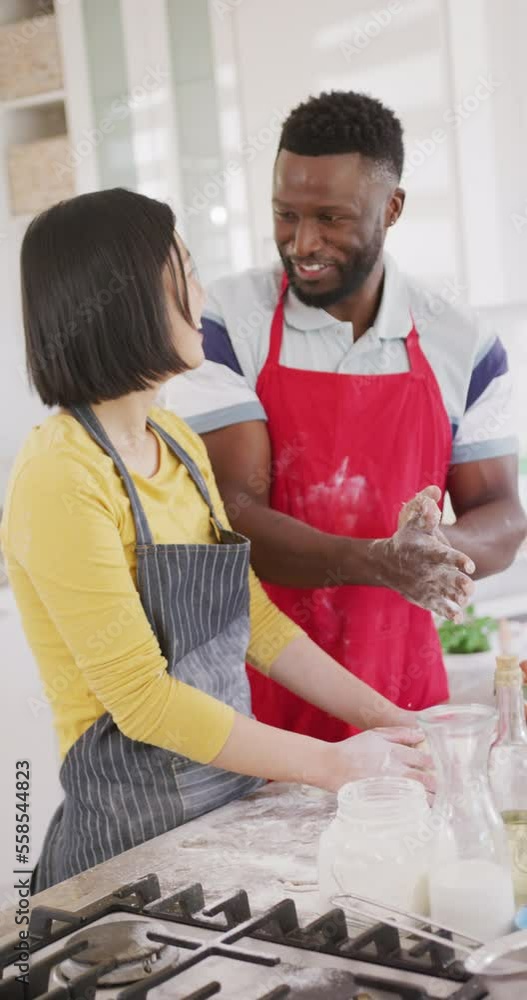 Vertical video of happy diverse couple baking in kitchen Vertical video of happy diverse couple baking in kitchen