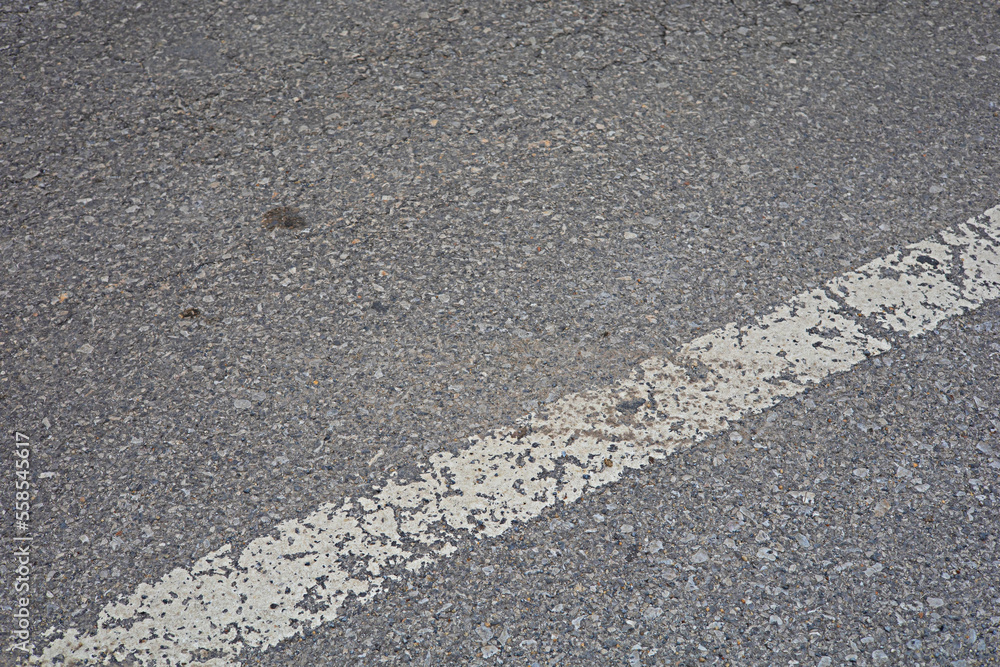 The old white traffic lines on the road surface are damaged and peeled off. The old white traffic lines on the road surface are damaged and peeled off.