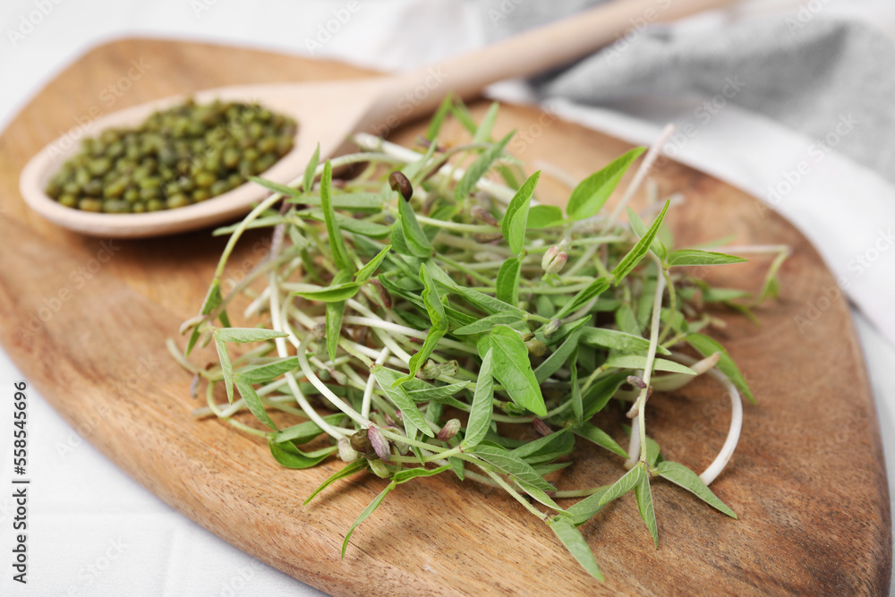 Wooden board with mung beans and sprouts on light table, closeup Wooden board with mung beans and sprouts on light table, closeup