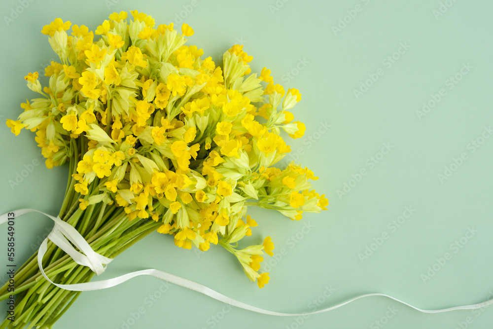 Bouquet of primrose on the table, top view. First spring flowers, yellow wildflowers. Floral background for women's day banner, birthday card or mother's day card