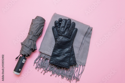 autumn accessories umbrella, gloves and tippet on pink background