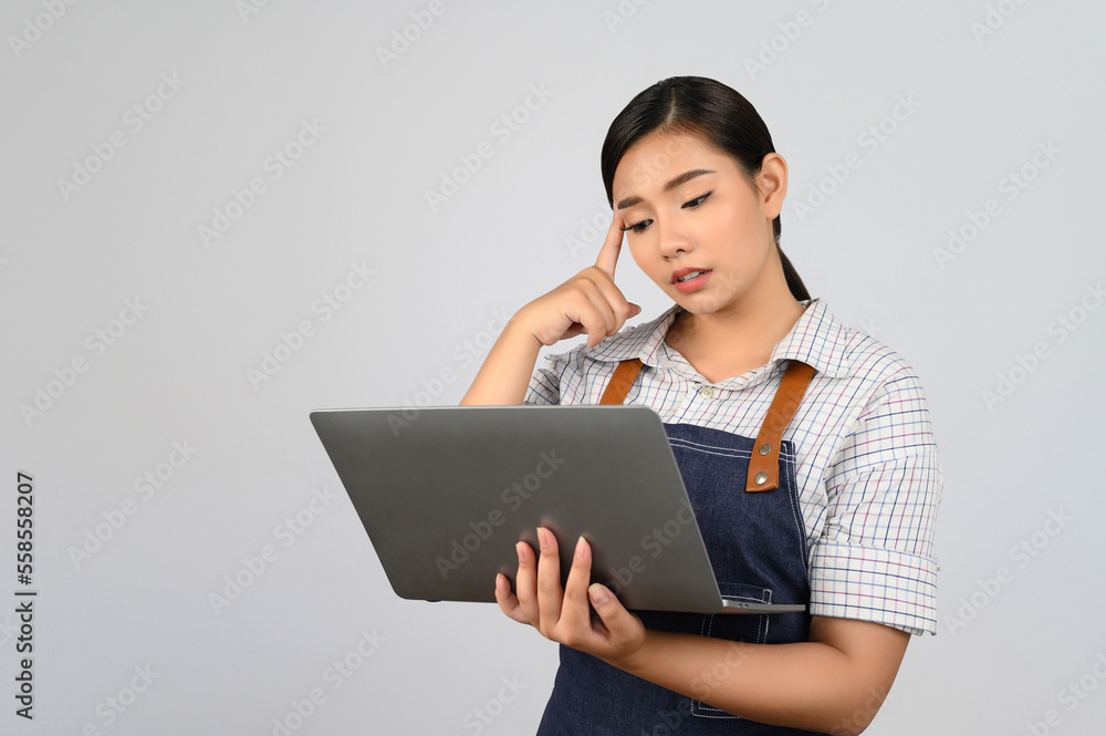 Portrait of young asian woman in waitress uniform pose with laptop computer Portrait of young asian woman in waitress uniform pose with laptop computer