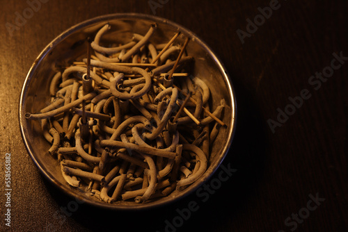 Close of shot of ash of incense stick on wooden table and dark background. Selective focus on Incense stick Ash.