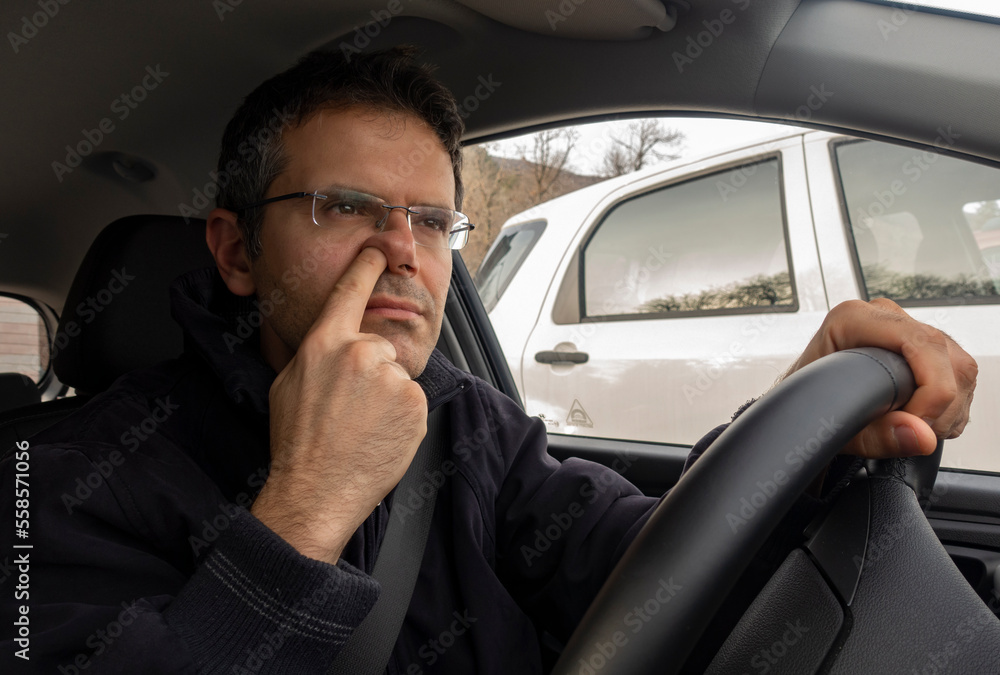 Man in car with finger into nose while driving. Man in car with finger into nose while driving.