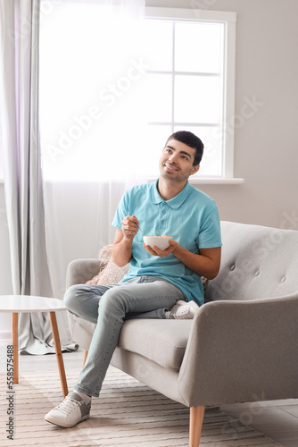Young man eating cornflakes...