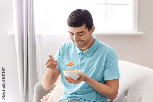 Young man eating cornflakes...